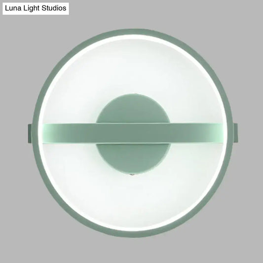 Minimalist sage green wall lamp with a matte frame and glowing white warm light LED ring for bedroom use