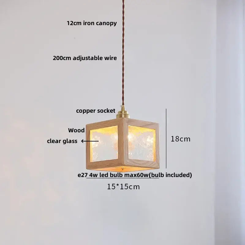 A warm-lit 18cm cube-shaped minimalist walnut and brass glass led pendant lamp for dining room use