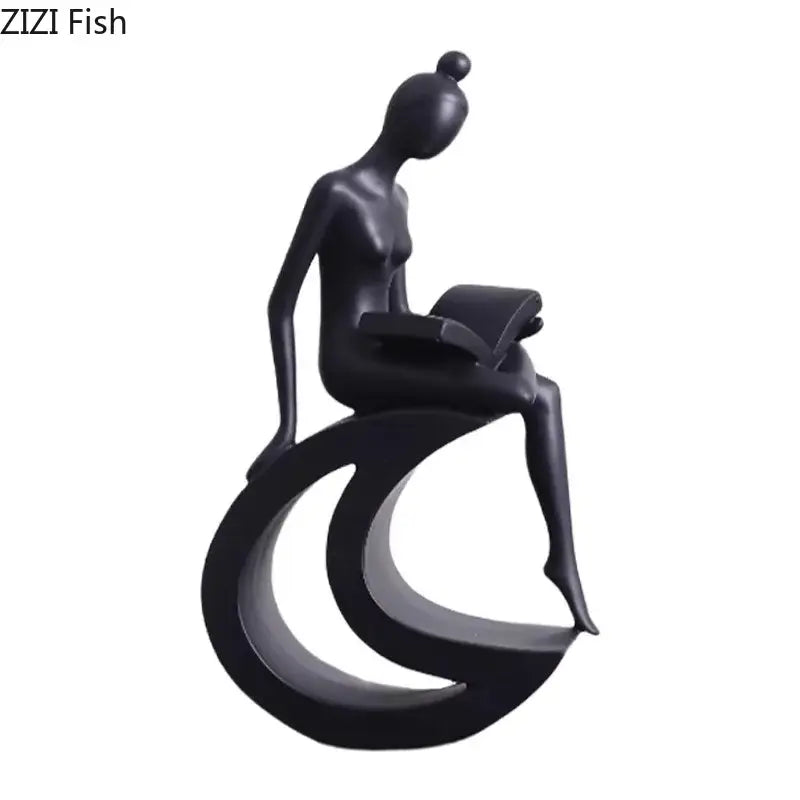 Black glossy resin abstract figures sculpture of a stylized woman seated on a crescent base reading a book for living room decor