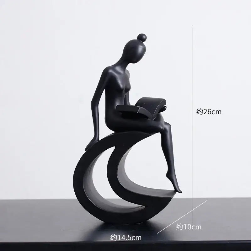 Black glossy resin abstract figures sculpture of a stylized seated woman reading for living room decor