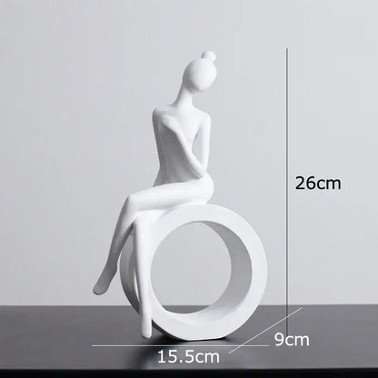 Minimalist white ceramic abstract figures sculpture of a seated woman with hair in a bun for living room decor