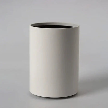 Minimalist white cylindrical wastebasket with matte finish and black interior complements decorbites led ceiling light