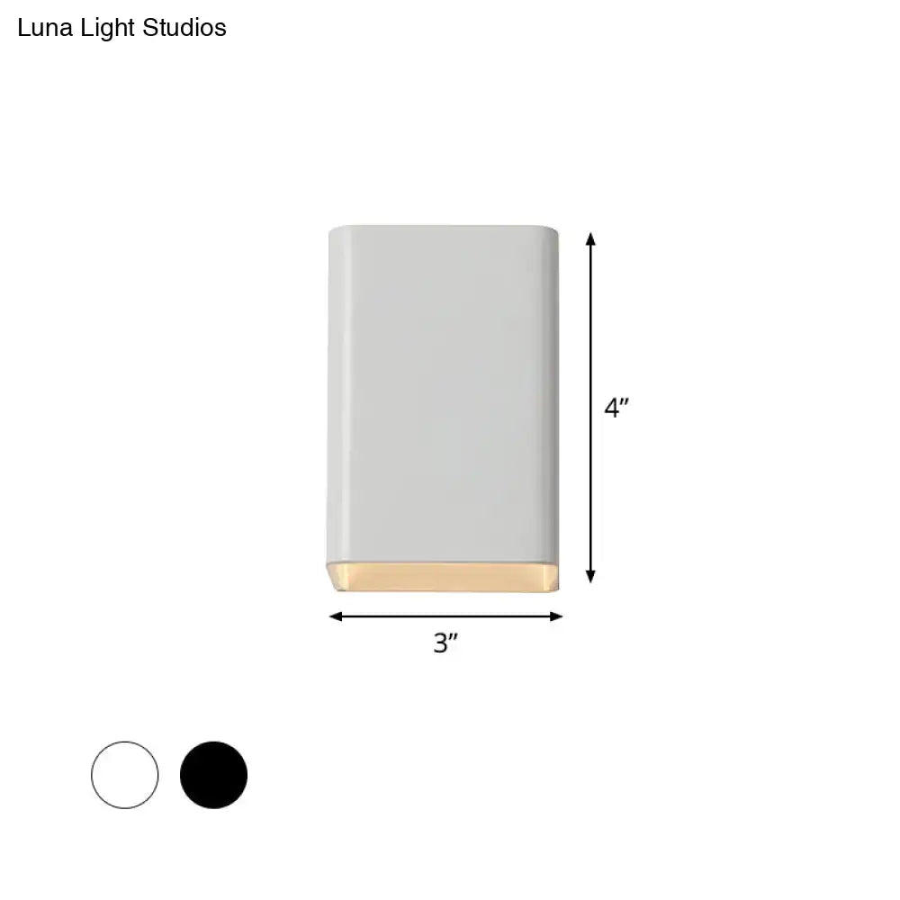 Minimalist wall lamp with a matte white cube shade and warm brass base designed as a sleek bedroom sconce
