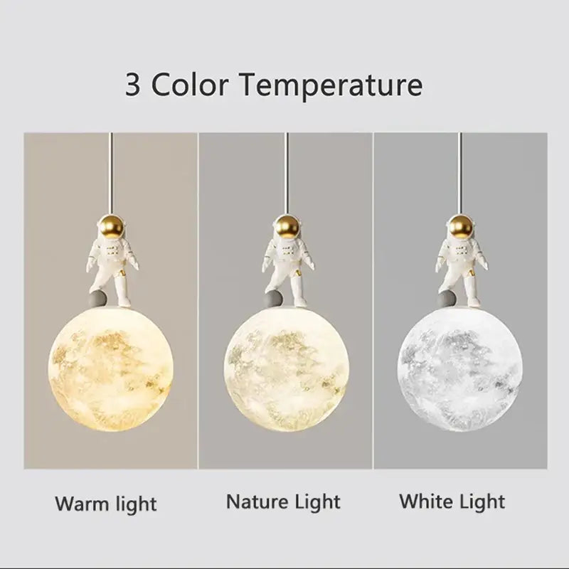 Minimalist white astronaut pendant light with gold helmet stands on textured moon lamp with three color settings decorbites astronaut pendant