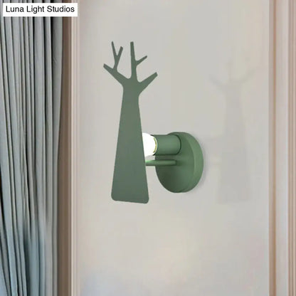 Matte sage green tree wall mount bedroom sconce shaped as a minimalist white deer with branching limbs in green grey white