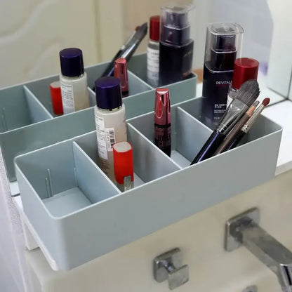 Light blue plastic divided storage box with multiple compartments for makeup and brushes organizer
