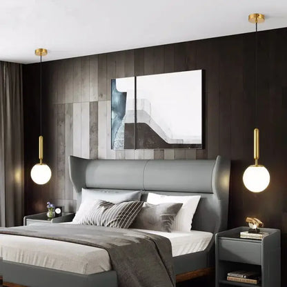 Gray upholstered wingback bed with tufted headboard and matching nightstands under minimalist white decorbites glass ball pendant light