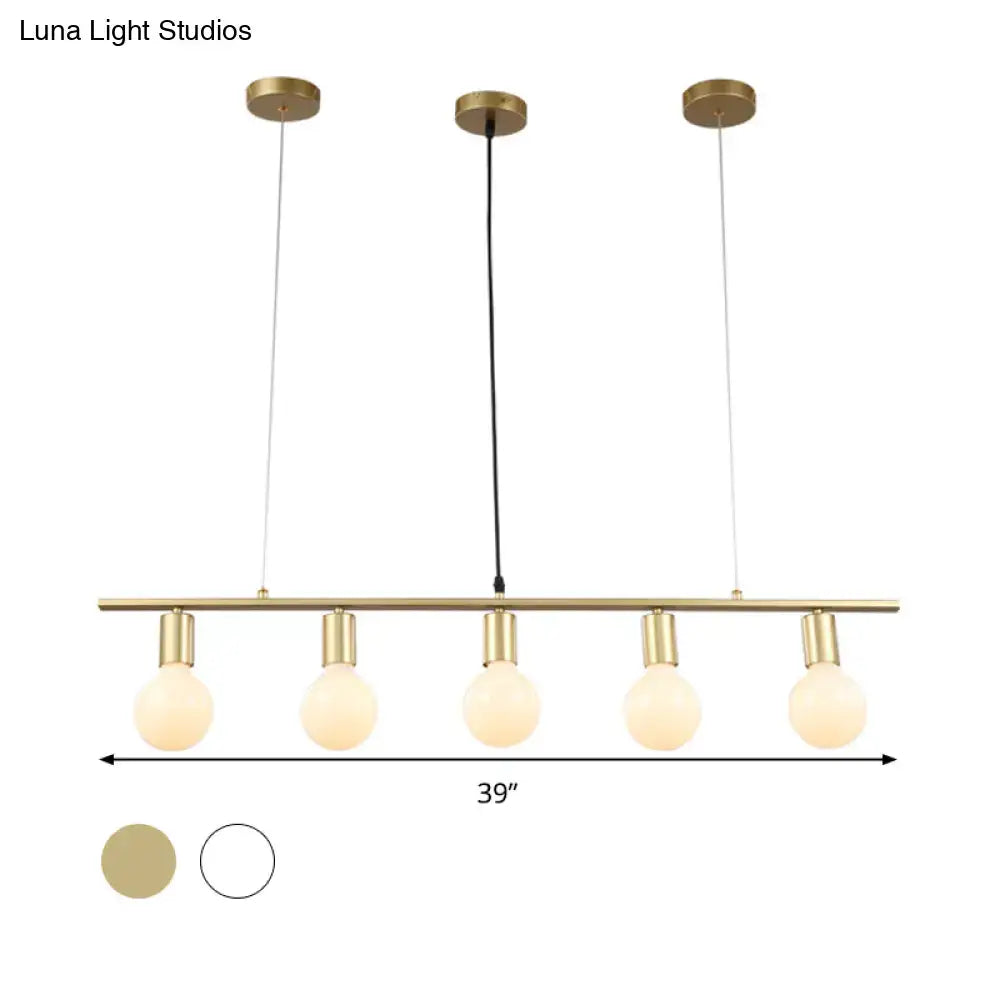 Modern brass pendant light fixture with five exposed globe bulbs and white gold linear metal island lighting design