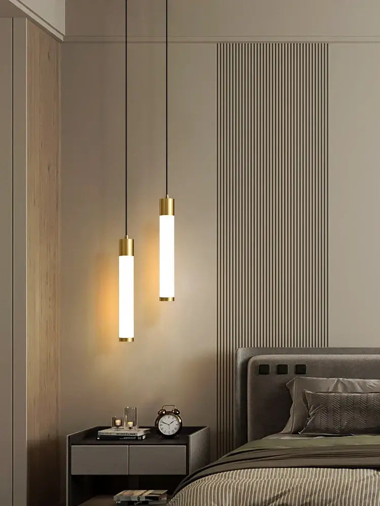 Two sleek cylindrical pendant lights with white finish and gold accents form a minimalist linear pendant light for kitchen islands