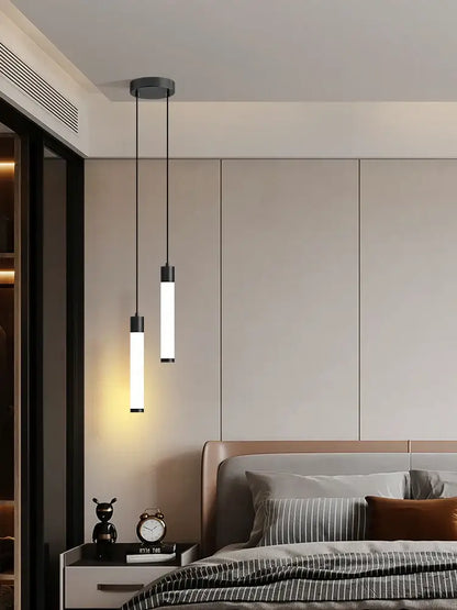 Two sleek cylindrical pendant lights with black fixtures and frosted glass shades complement a minimalist white finish linear pendant light for kitchen island lighting
