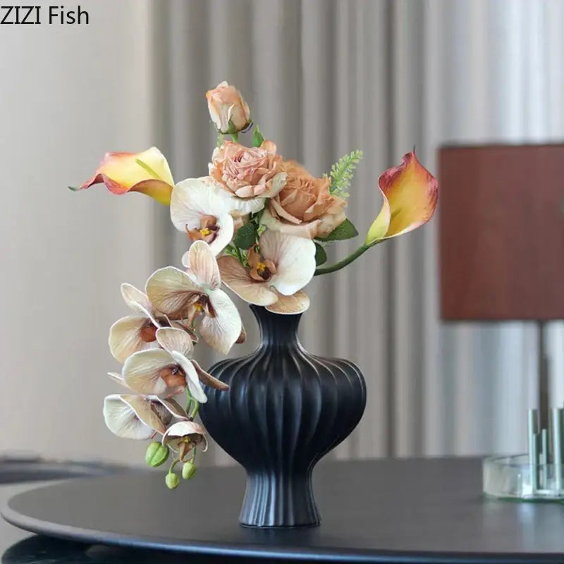 Black ribbed ceramic vase with peach cream and yellow calla lilies and orchids complementing decorbites heart shape ceramic
