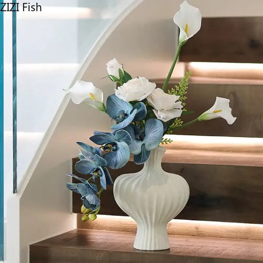 Minimalist white heart shape ceramic vase with vertical ridged texture holding blue orchids and white calla lilies decorbites heart shape