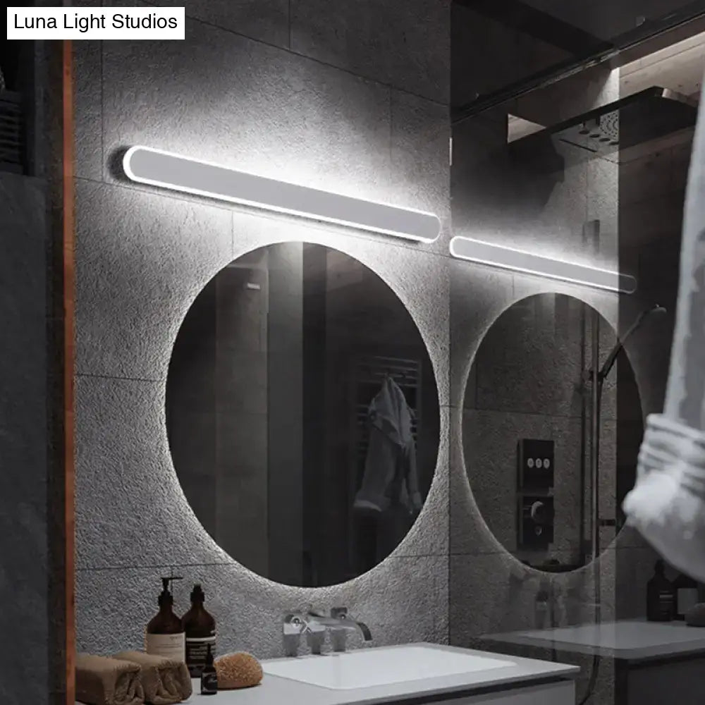 Modern minimalist white led mirror wall sconce with sleek finish and warm white light mounted above two circular mirrors