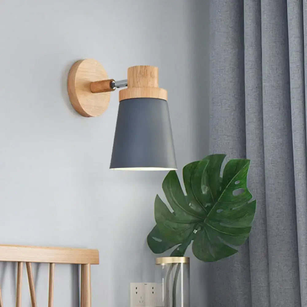 Modern wall lamp sconce with matte gray conical shade and natural wood accents on circular base and arm