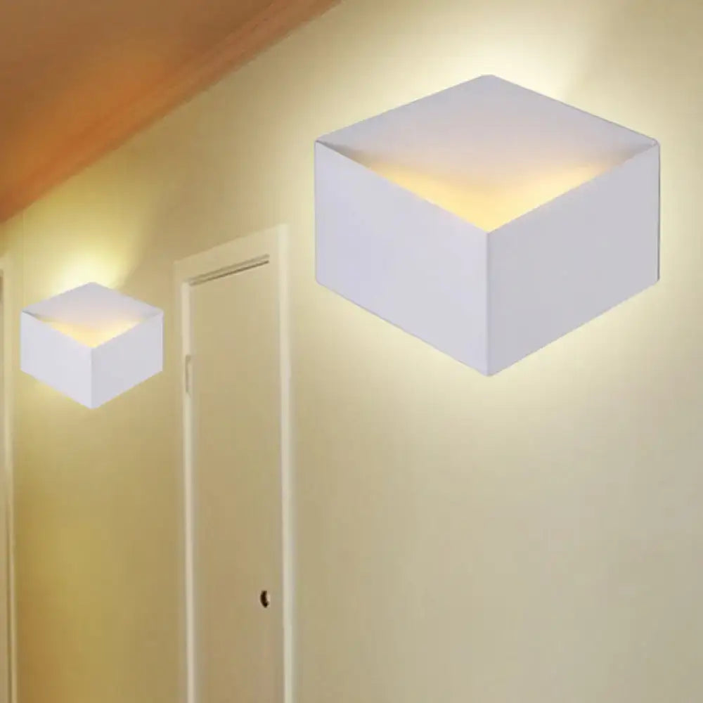Minimalist white metallic geometric wall lamp with cube shape and warm glow for corridor lighting