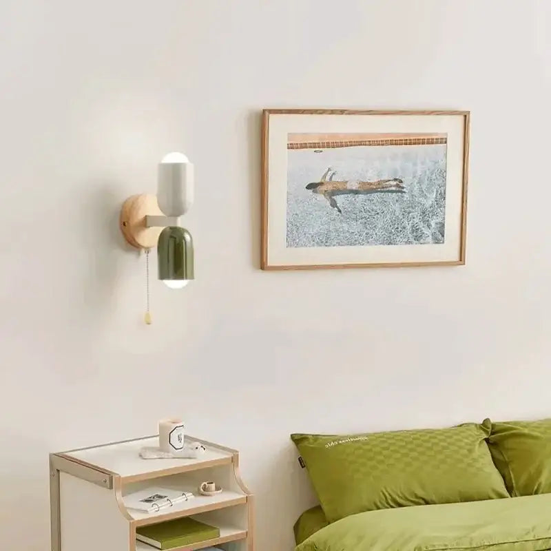 Modern two-toned wall lamp with matte white and olive green sections on a circular wooden base from decorbites cream zipper