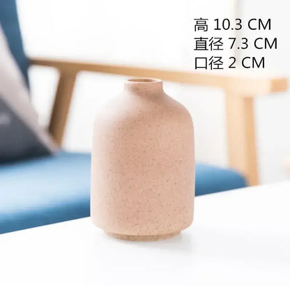 A matte beige speckled decorbites ceramic vase with rounded minimalist design for dining room decor