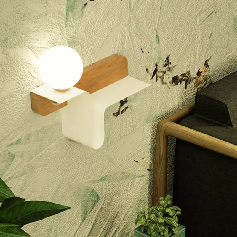 Minimalist white wall lamp with frosted glass shelf and spherical bulb in matte white plastic and light wood accents