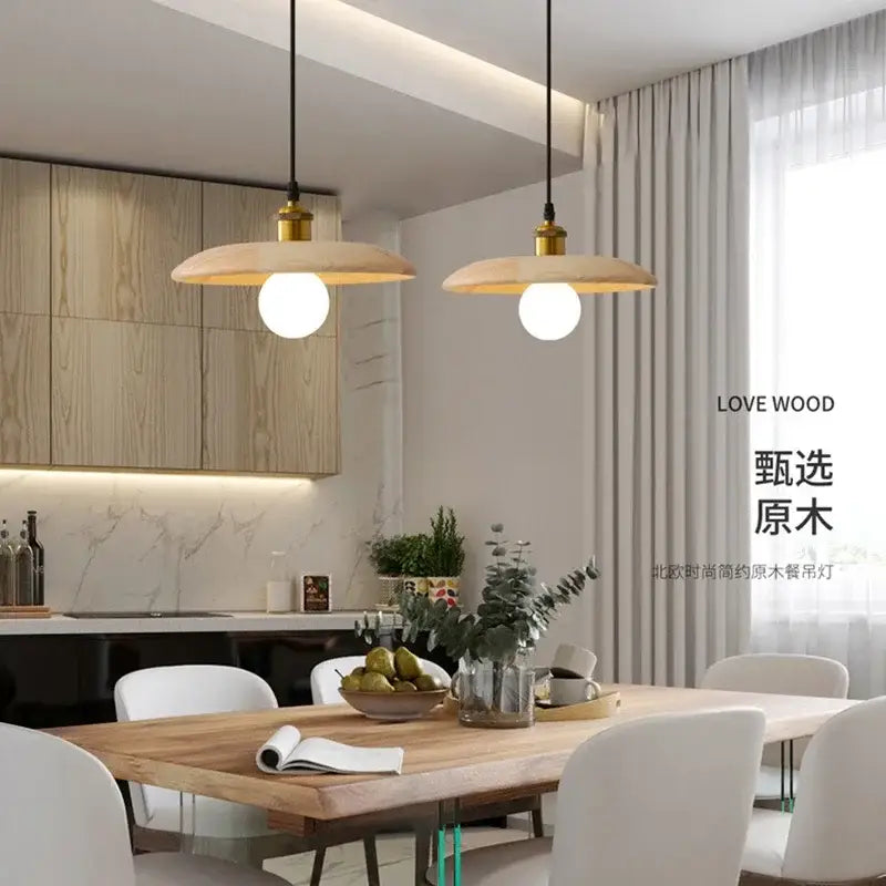 Pair of minimalist wood and brass pendant lights with led bulb and three-color dimming suspended above dining table