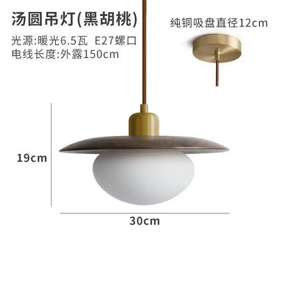 A modern cream wind pendant light with matte black disc top and frosted white glass globe for dining room decorbites