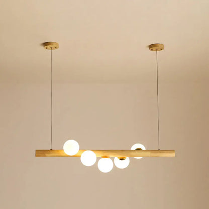 Minimalist wood and glass linear island pendant with natural wood bar and five frosted globe bulbs for kitchen lighting
