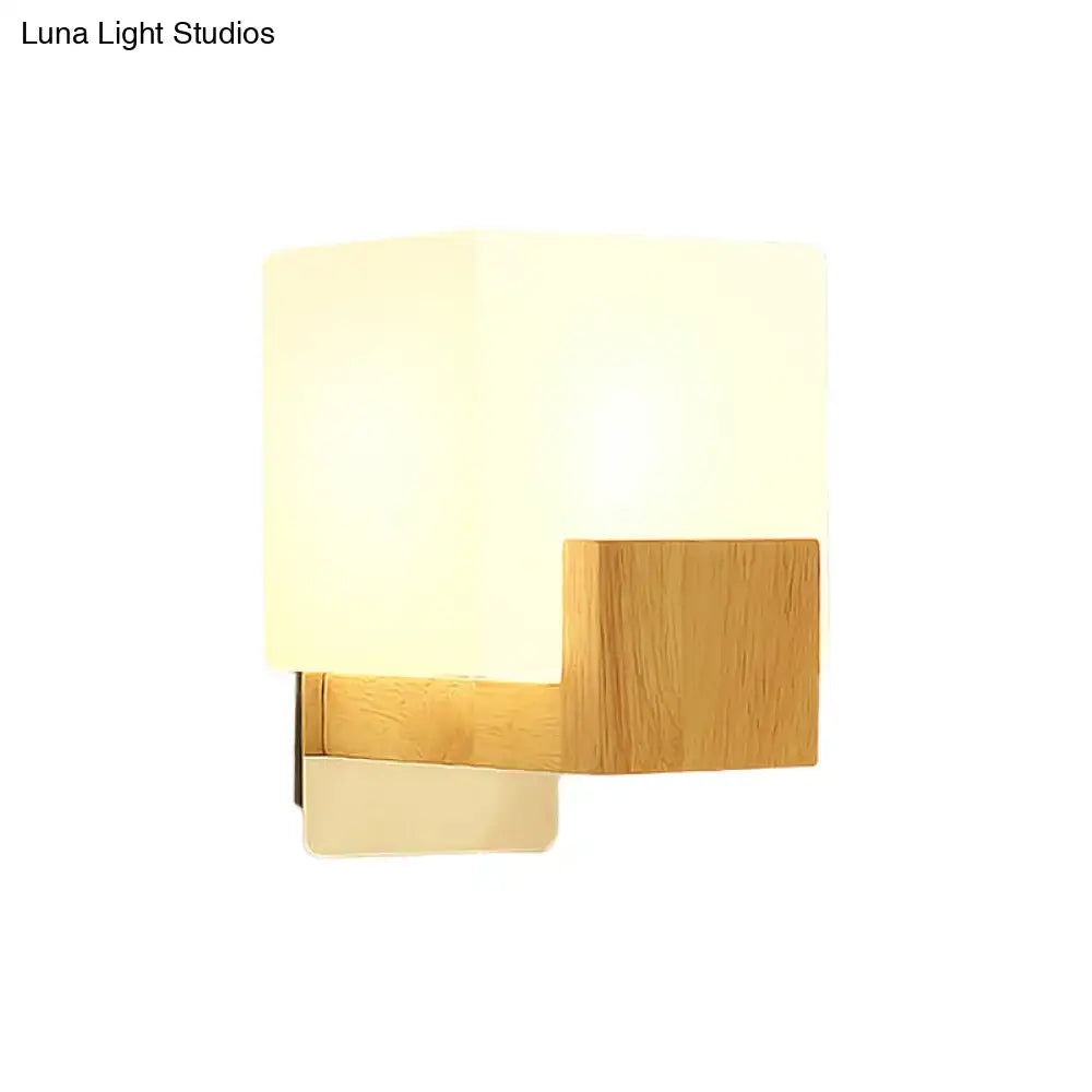 Minimalist wood and opal glass wall sconce with warm diffused glow serving as a modern bedroom wall light