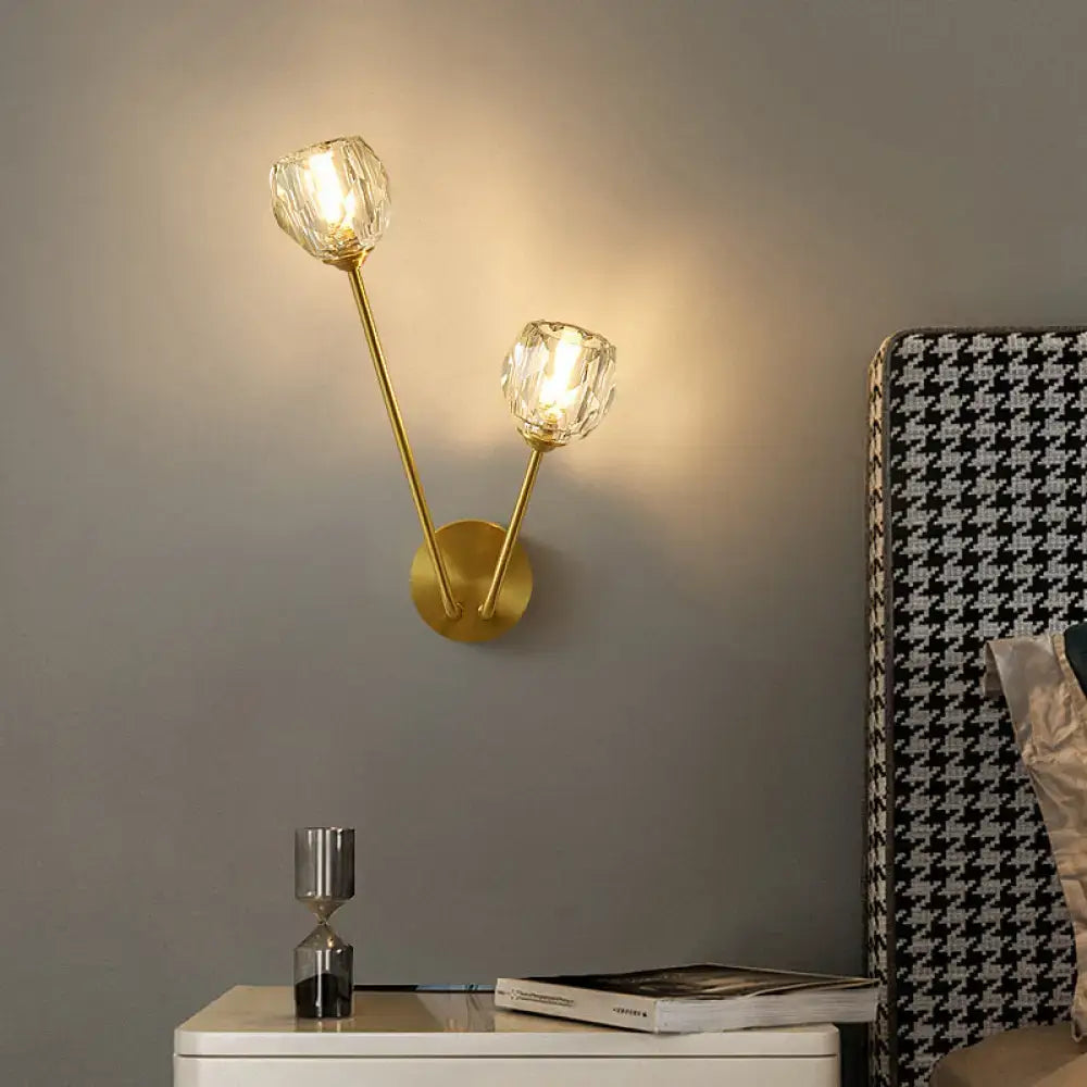 Gold-toned brass branch wall light with two faceted crystal shades designed as a minimalistic wall lamp for bedroom use