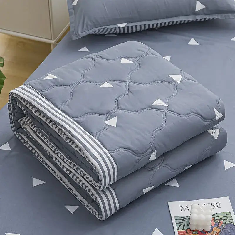 Gray quilted blanket with white triangular patterns and striped border in mint green daisy print quilt set decorbites daisy print