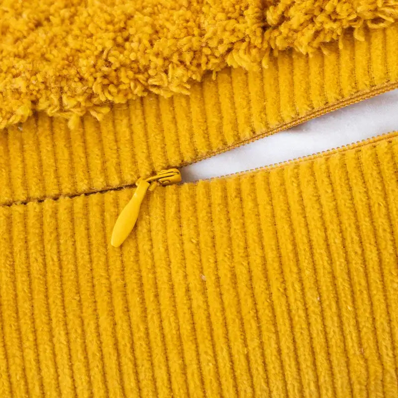 Yellow corduroy cushion cover with plush fuzzy trim and matching zipper pull for diamond tassel cushion cover use