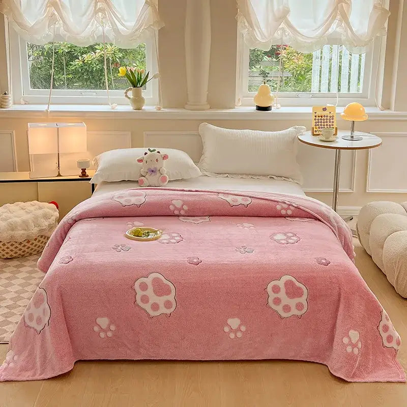 Pink plush blanket with soft fuzzy texture and lighter pink paw print patterns matching decorbites dinosaur patterns snowflake design