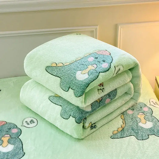 Soft mint green snowflake velvet blanket with embroidered dinosaur patterns featuring pink cheeks and yellow accents