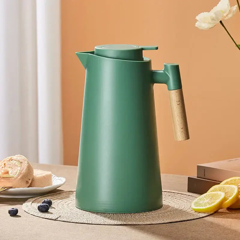 A sleek matte mint green double glazed thermos kettle with wooden handle and lid for modern kitchen use