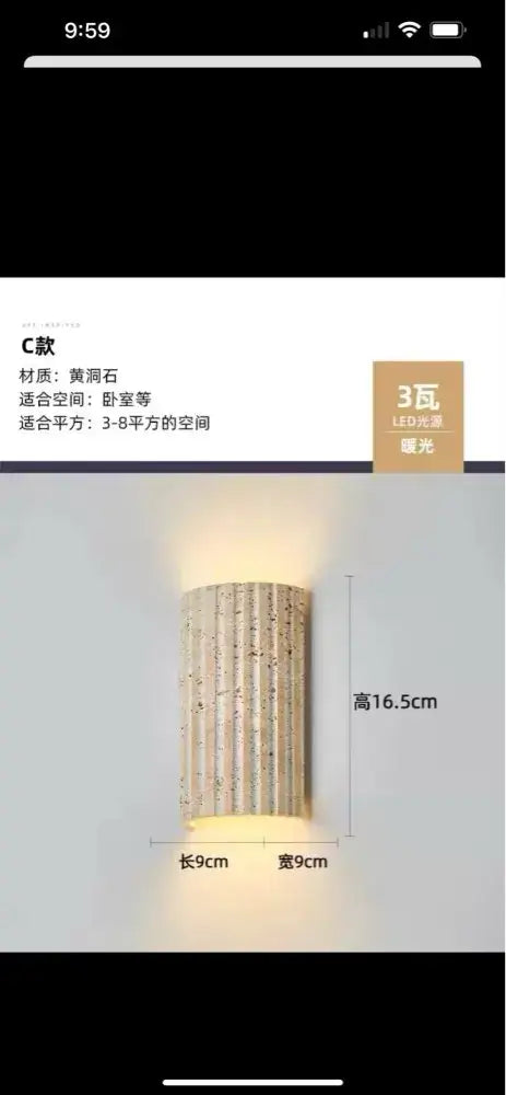 A cylindrical yellowish stone led wall lamp sconce with vertical grooves and warm glow, 9cm by 9cm