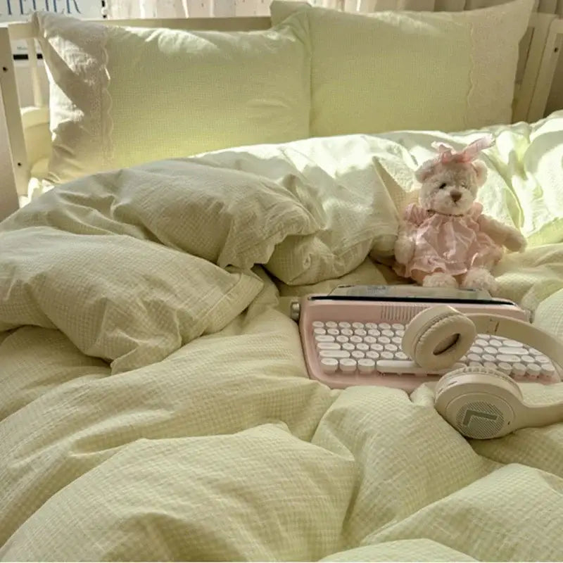 Pink keyboard with white keys and matching headphones resting on mint green french lace washed cotton bedding sets by decorbites