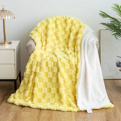 A cozy yellow and white checkered plush blanket with a soft texture paired with mint green geometric jacquard flannel sofa cover decorbites