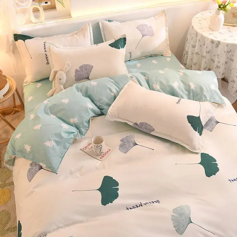 A mint green and white bedding set with a decorbites cartoon print of ginkgo leaves in teal gray and dark green