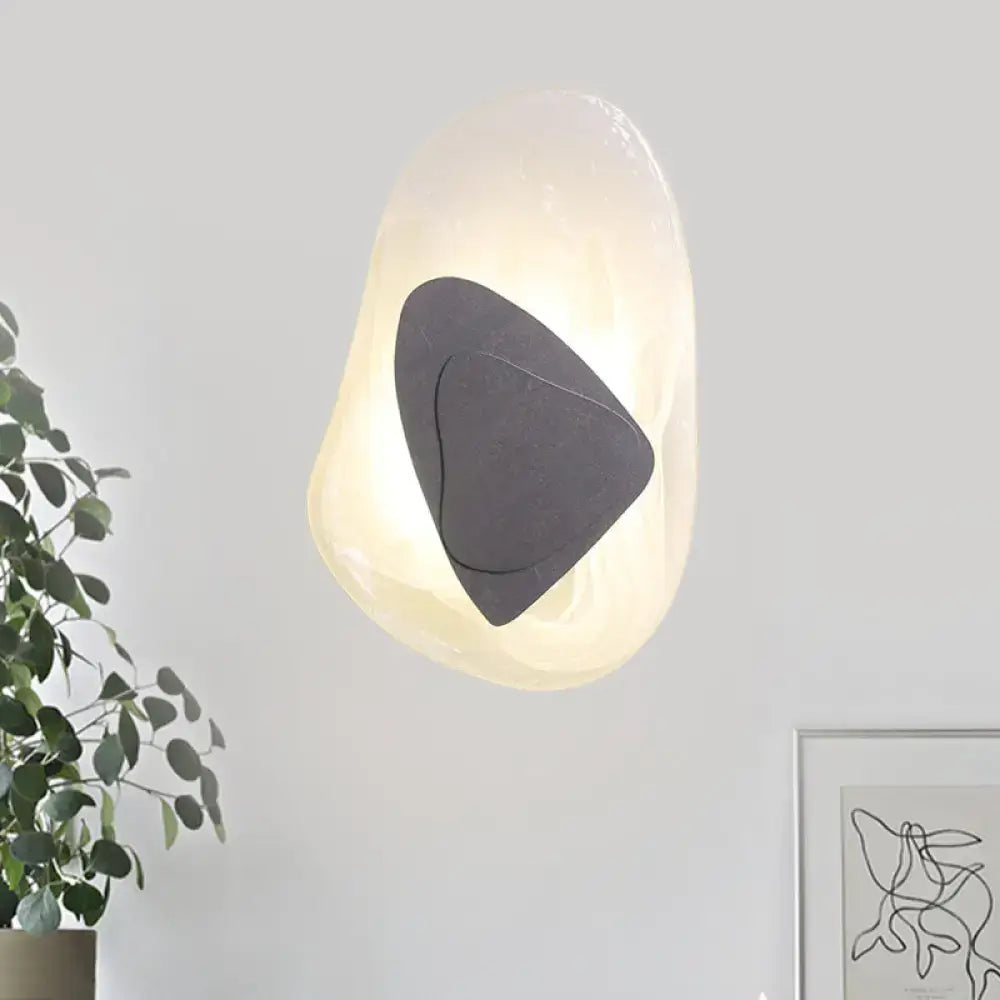 Modern abstract clear glass rock wall sconce with warm glow direct wired electric design in black and gold for dining room