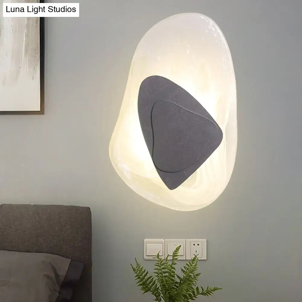 Modern abstract clear glass rock wall sconce with direct wired electric black geometric overlay for dining room lighting