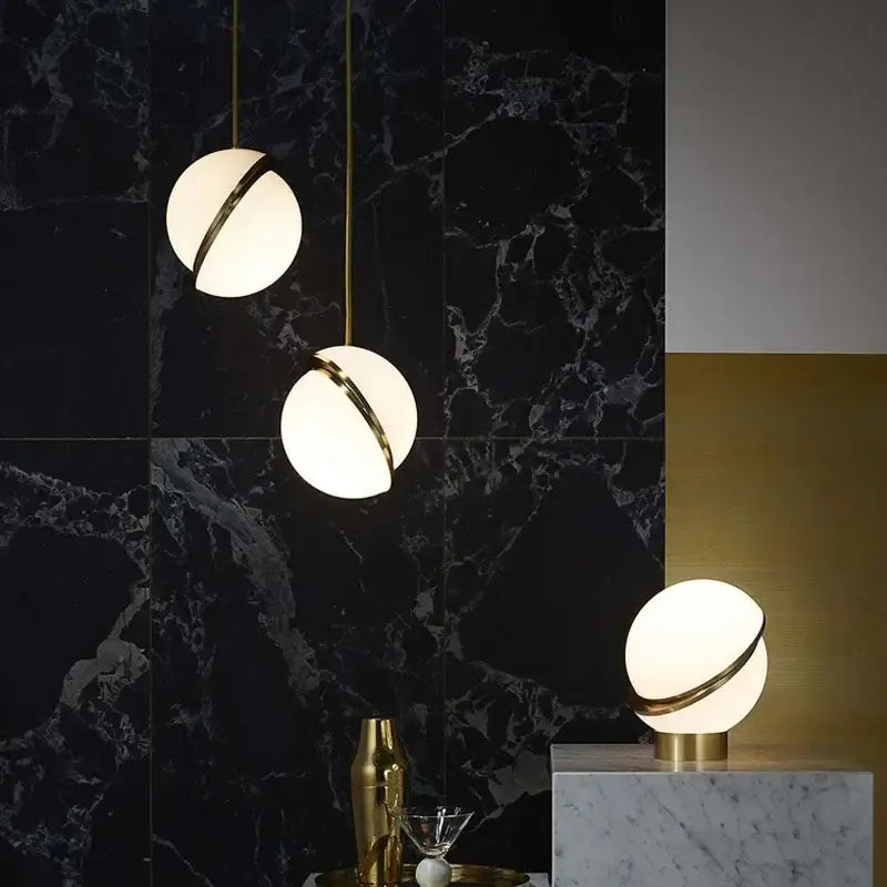Modern acrylic ball pendant lamp and table lamps with frosted glass globes and gold-toned rings for living room lighting