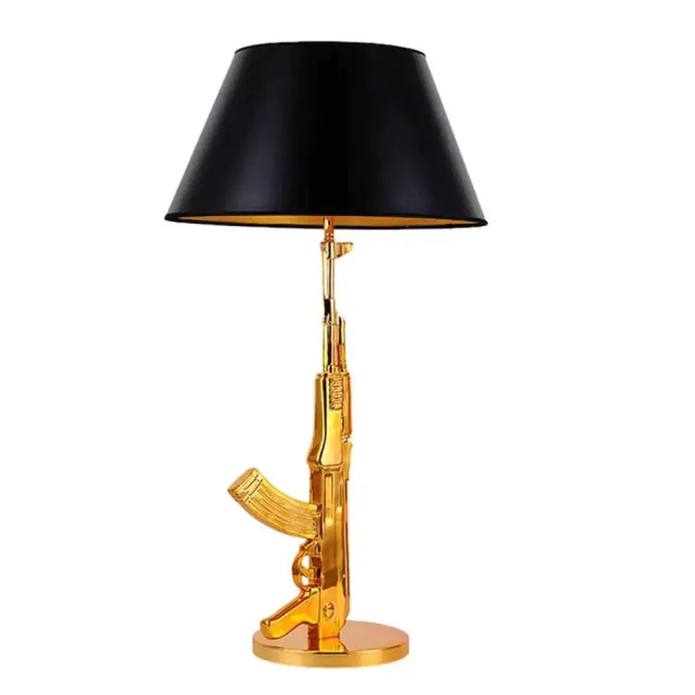 Modern ak47 gun lounge floor lamp in gold with a silvery gold lustre ak47 rifle base and black fabric shade