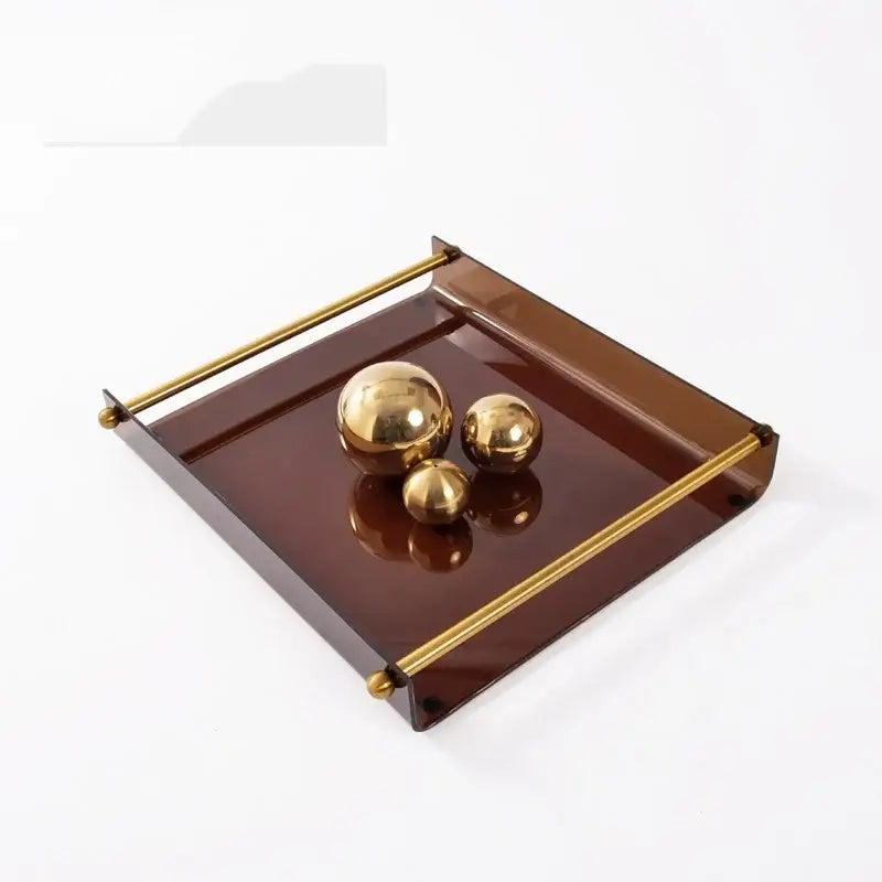 Modern amber brown translucent acrylic fruit plate tray with gold-toned metal handles and corner accents for dining room use