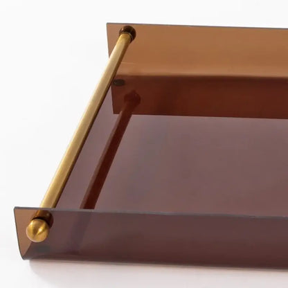 A sleek modern amber acrylic fruit plate tray with polished brass handles and rounded finials for dining room use