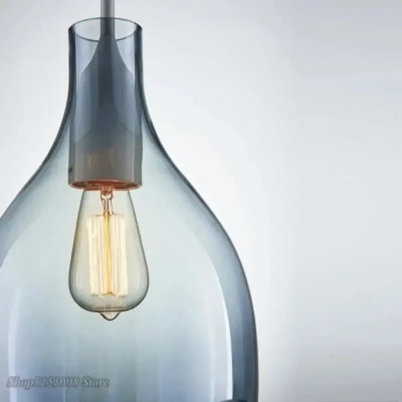 A sleek translucent gray glass pendant light with warm-toned filament bulb for modern kitchen pendant lights
