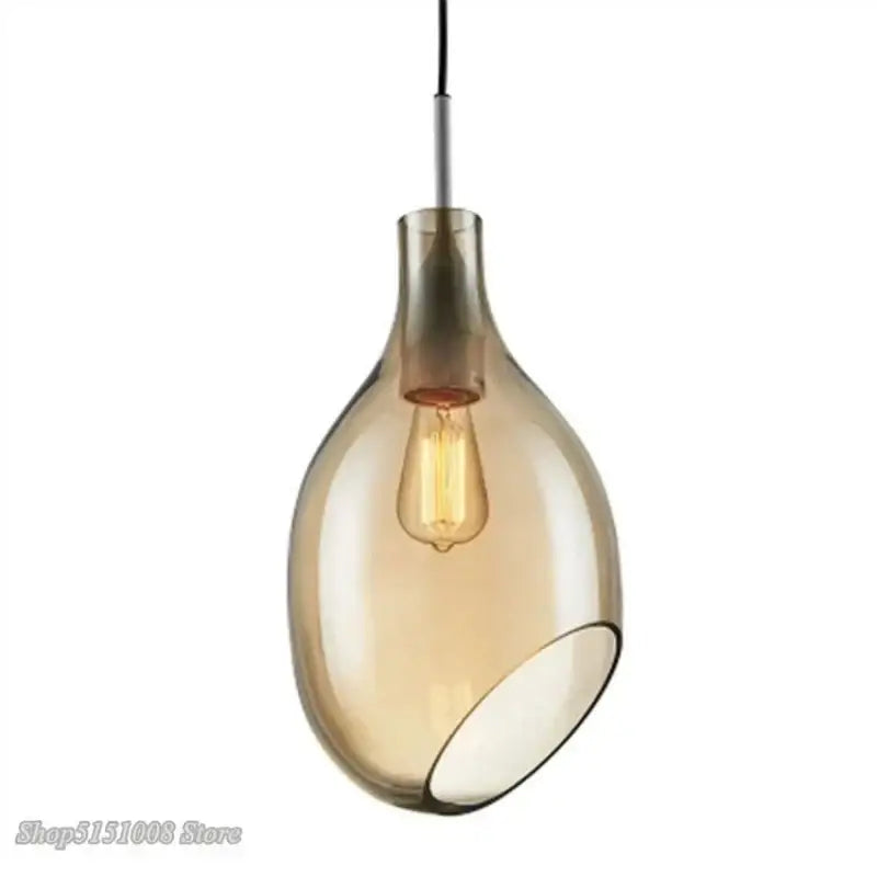 A sleek amber-tinted glass pendant light with modern teardrop shape and exposed edison bulb for kitchen use