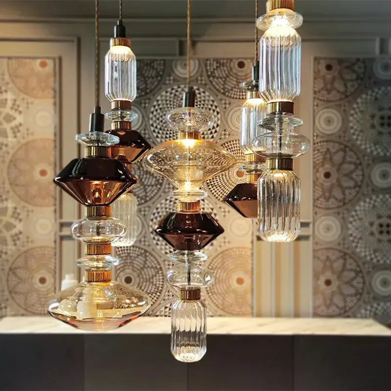 Modern amber and brown glass ballet pendant lamp featuring layered glass and gold metal fittings for dining room