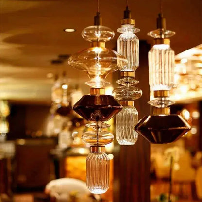 Modern amber and brown glass ballet pendant lamp with faceted glass and gold metal fittings for dining room lighting