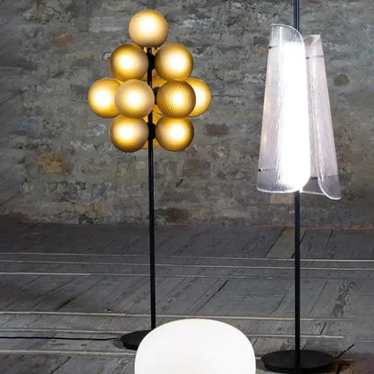 Modern amber bubble glass lamp set featuring a golden spherical globe floor lamp with black metal stand for living room