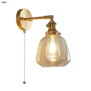 Modern amber clear glass wall sconce with textured amber-tinted glass shade and brass-finished decorbites clear glass hardware