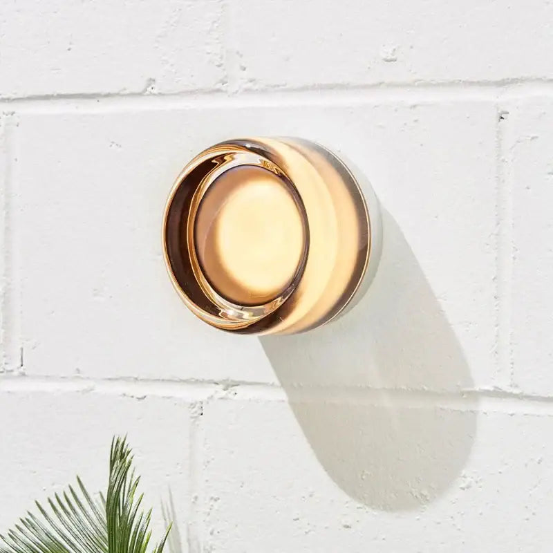 A sleek circular gold-toned glass soap dish complements the modern amber and cream glass sconce led wall lamp