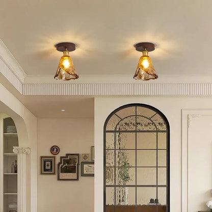 Two amber glass pendant led ceiling lamps with brass fixtures for modern dining room lighting
